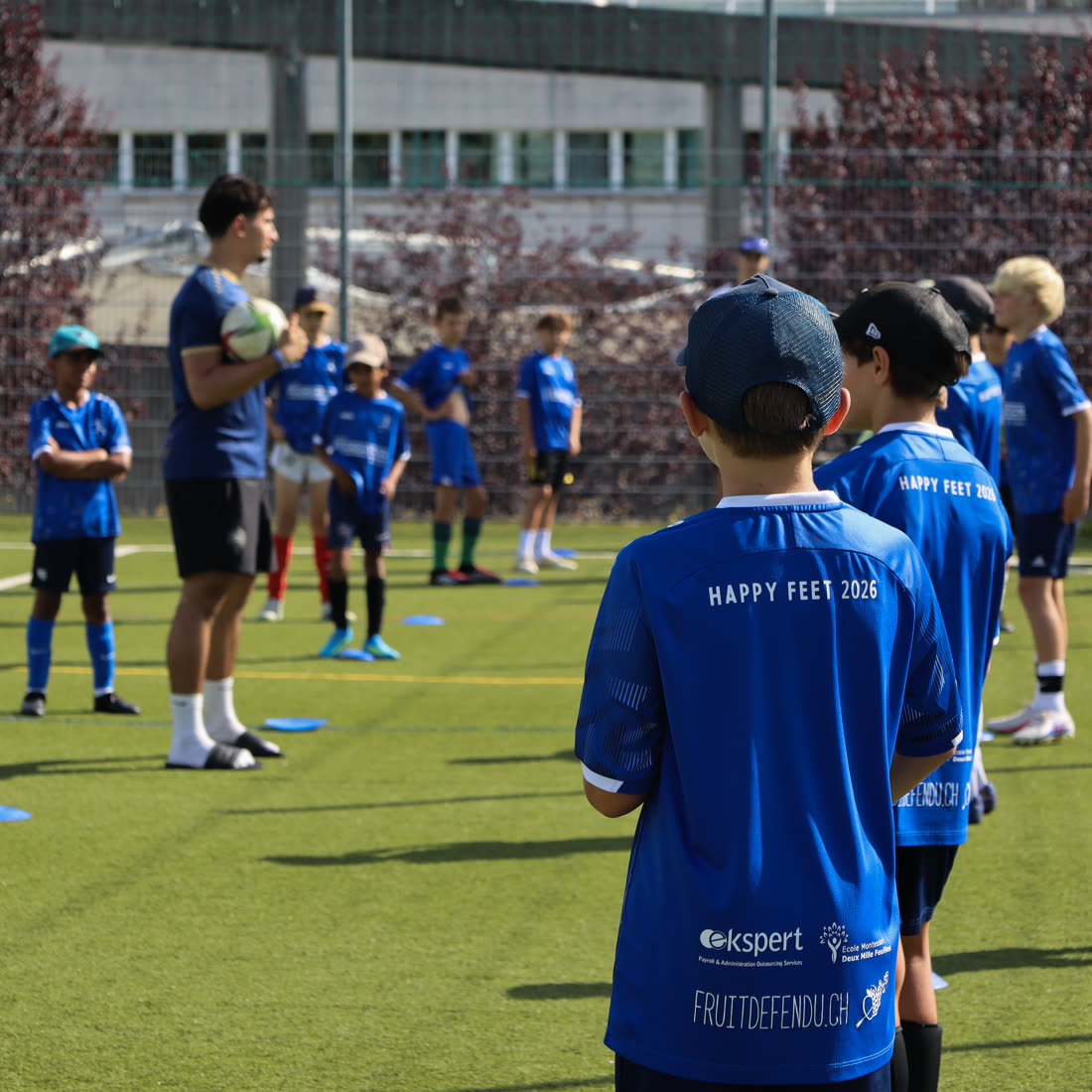 Les enfants écoutent les consignes du coach, maillot Happy Feet 2026