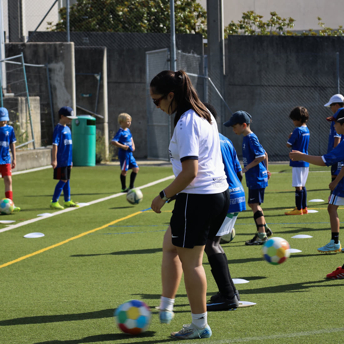 Une coach au milieu des enfants pendant l'échauffement